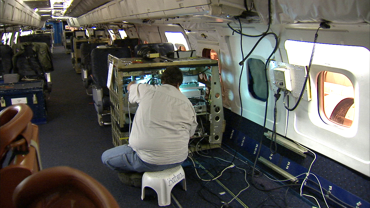 Engineer in a DC-8 preparing instruments for the GCPEx field campaign
