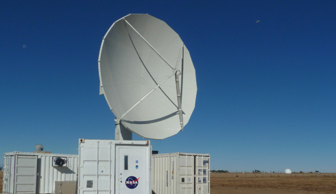 The NPOL instrument, a large radar dish attached to a trailer under a blue sky