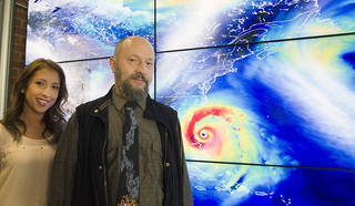 NASA tropical meteorologists Oreste Reale and Marangelly Fuentes pose with a hyperwall display of the Global Modeling and Assimilation Office's simulation of a hurricane.