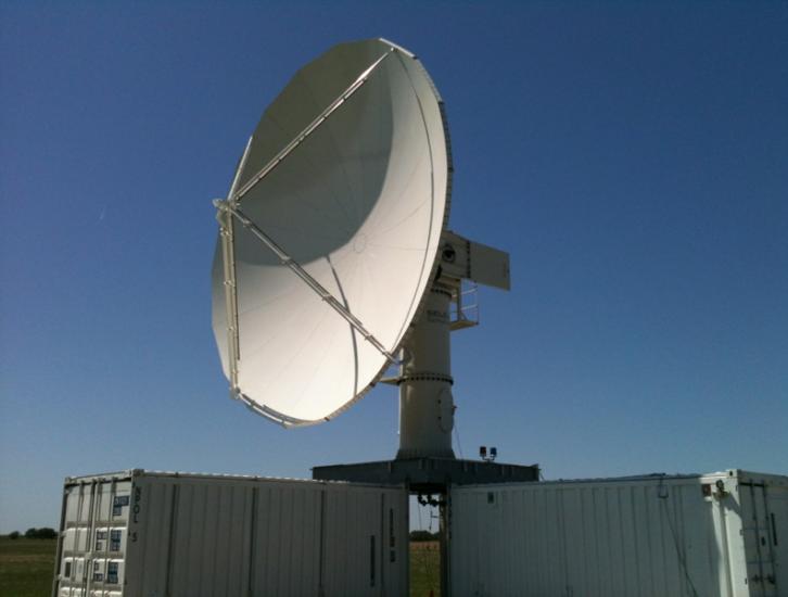 The NPOL instrument, a large radar dish attached to a trailer under a blue sky